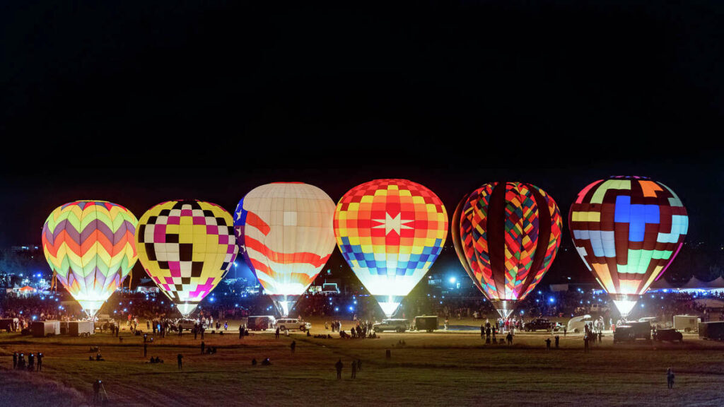 Great Reno Balloon Race balloon glow lined up in a field lighting up the night