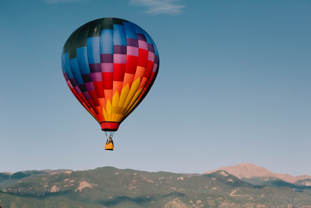 A hot air balloon against the panoramic view of the Rocky Mountains