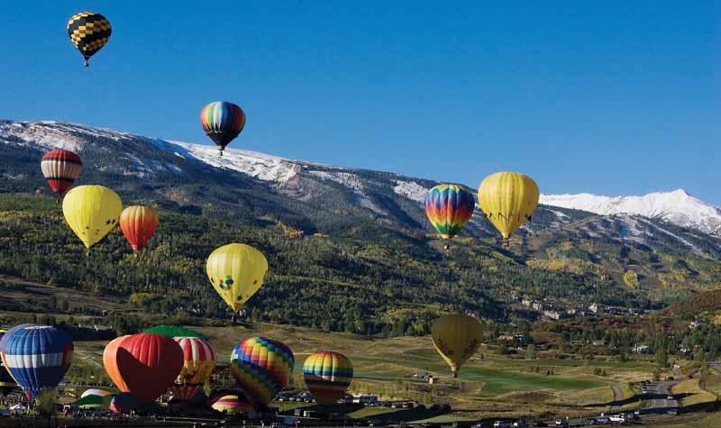 Snowmass Balloon Festival - hot air balloons ascending at the foot of the mountain in Snowmass village. 